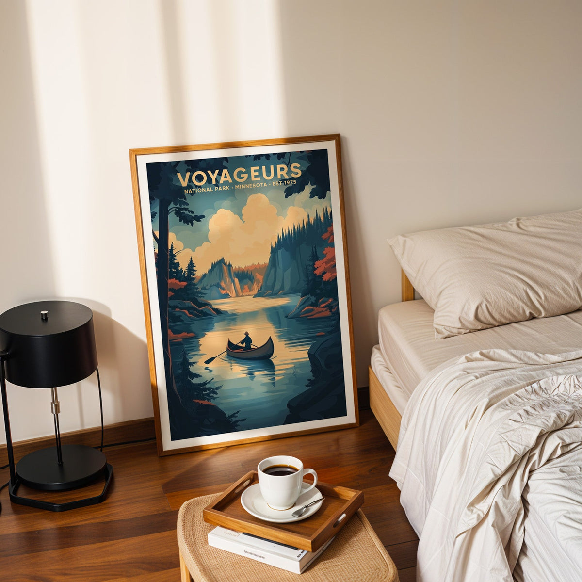 Voyageurs National Park print in an oak frame leaning on a bedroom floor beside the bed and a coffee tray