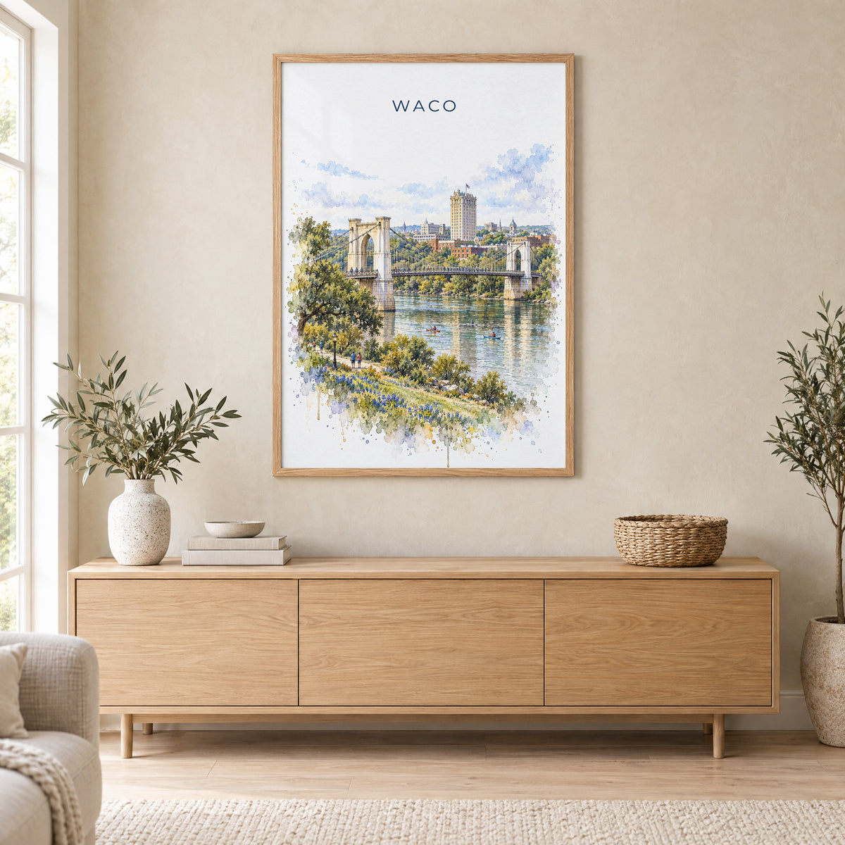 Waco watercolor print in an oak frame above a light wood sideboard in a Scandinavian living room