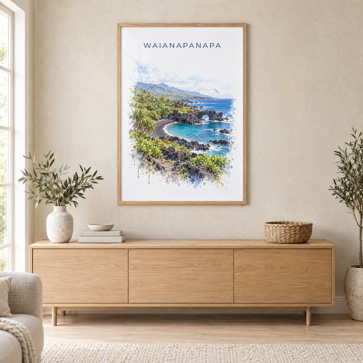 Waianapanapa State Park watercolor print in an oak frame above a light wood sideboard in a Scandinavian living room