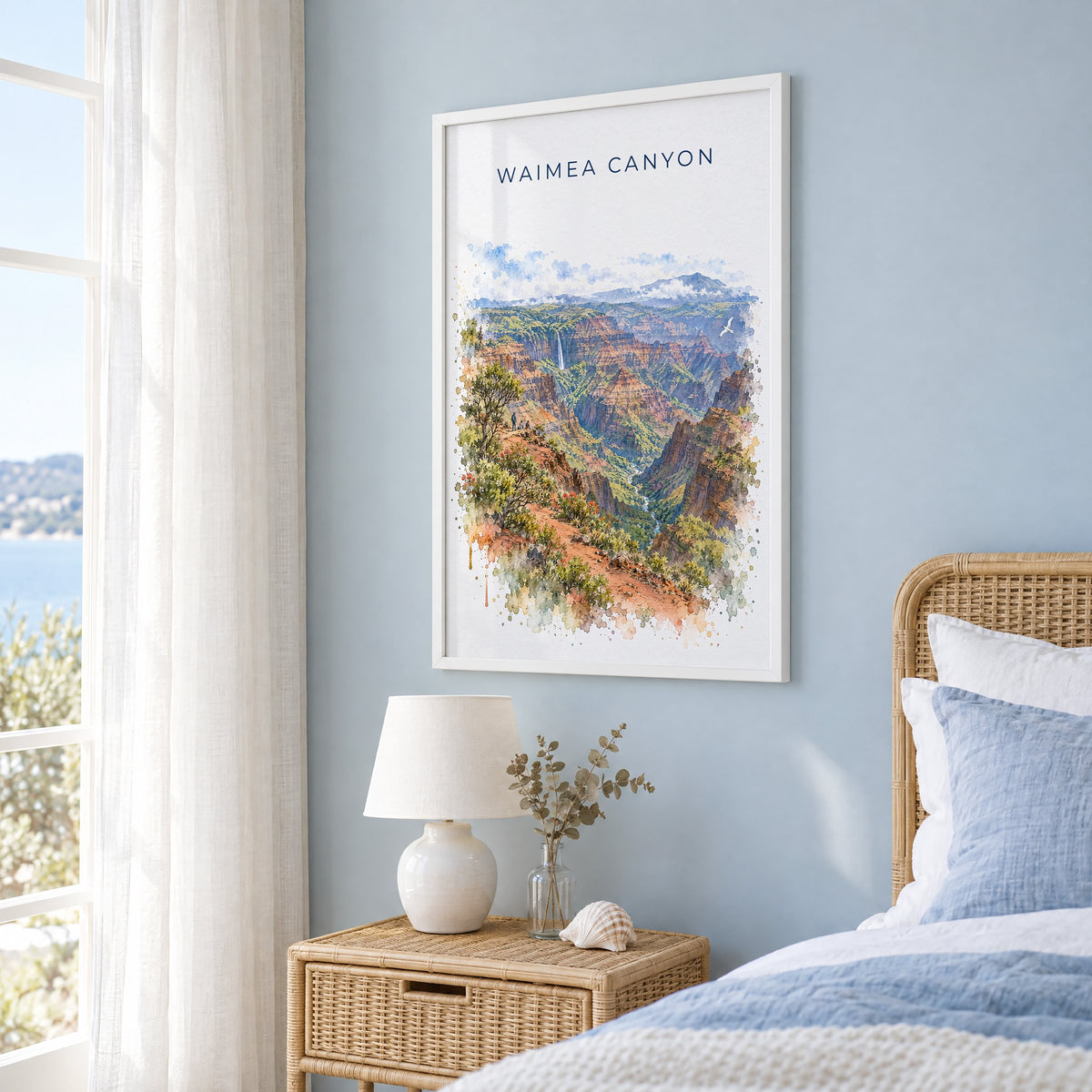 Waimea Canyon watercolor print in a white frame on a pale blue wall beside a rattan bed in a coastal bedroom