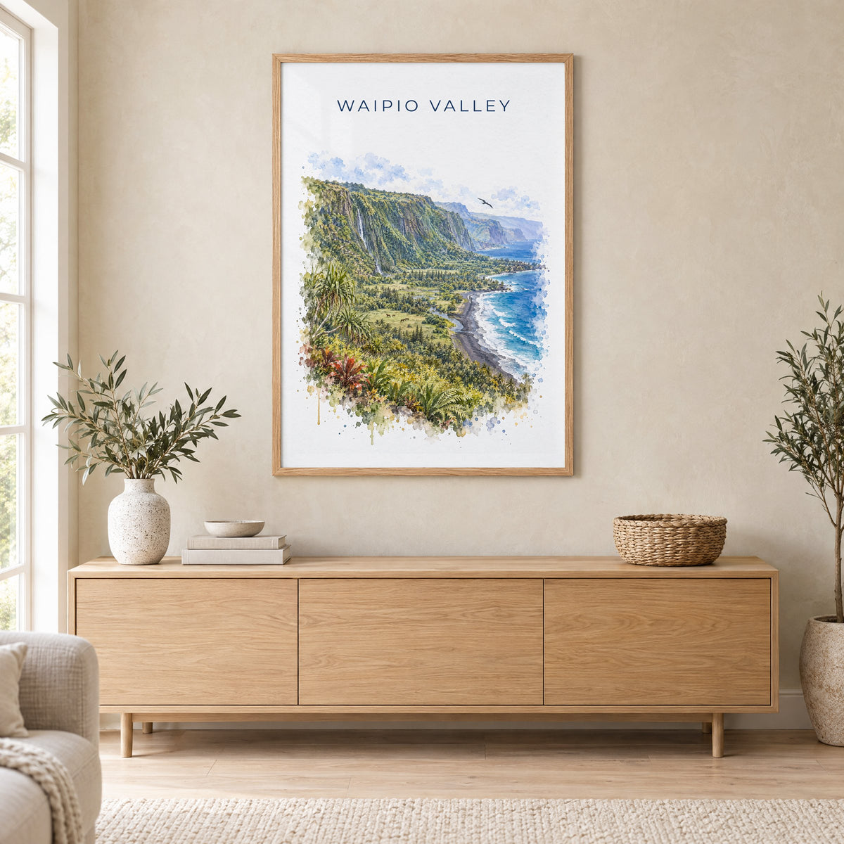 Waipio Valley watercolor print in an oak frame above a light wood sideboard in a Scandinavian living room
