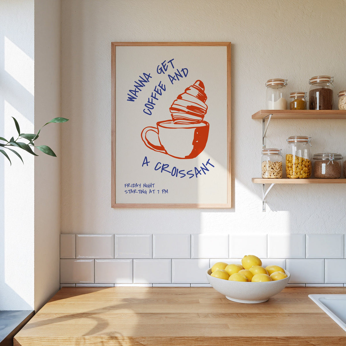Wanna Get Coffee and a Croissant print in an oak frame beside open kitchen shelves