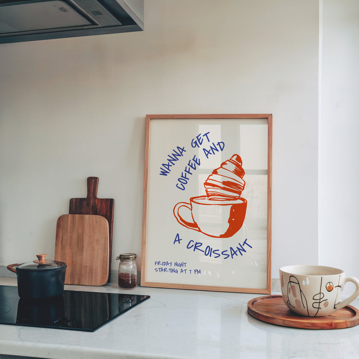 Wanna Get Coffee and a Croissant print in a pine frame on a marble counter