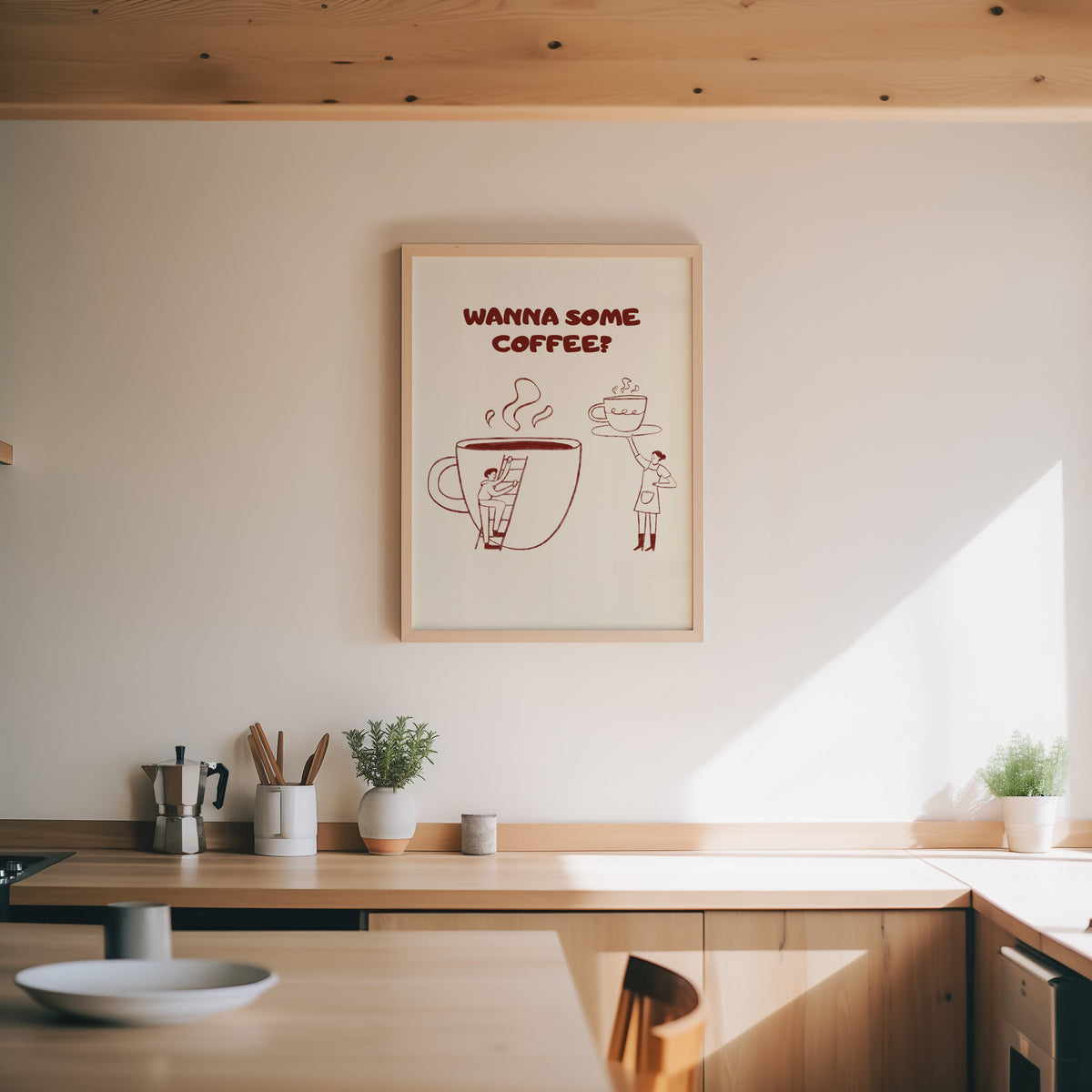 Wanna Some Coffee print in an oak frame above a wood counter with a moka pot and herbs