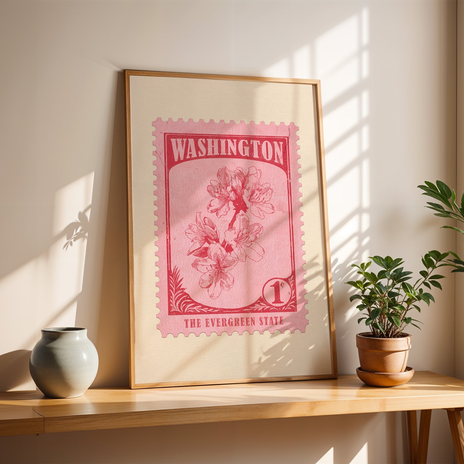 Washington Rhododendron stamp print in a light oak frame leaning on a table beside a stoneware vase