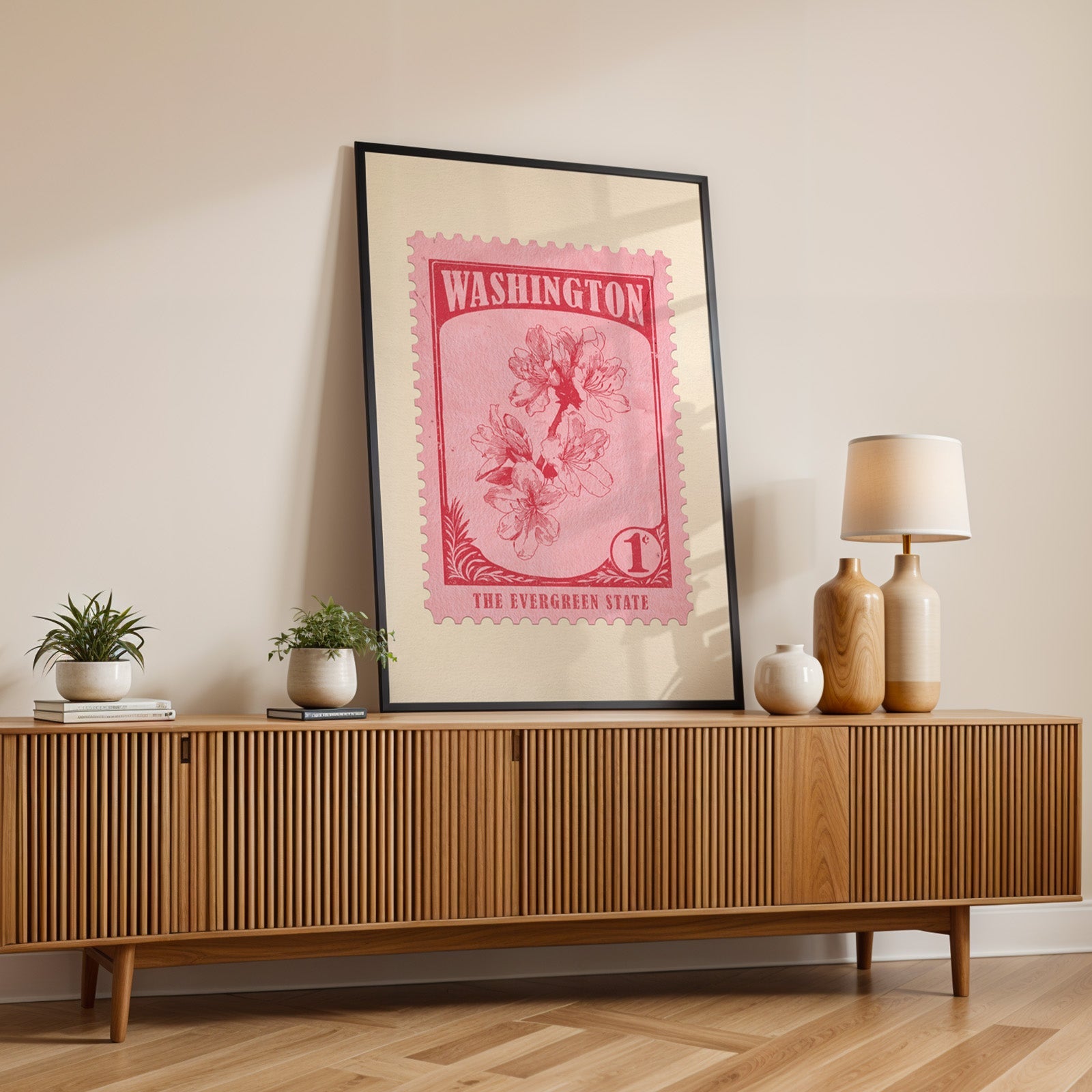 Washington state flower print in a black frame leaning on a fluted wood credenza with vases and a lamp