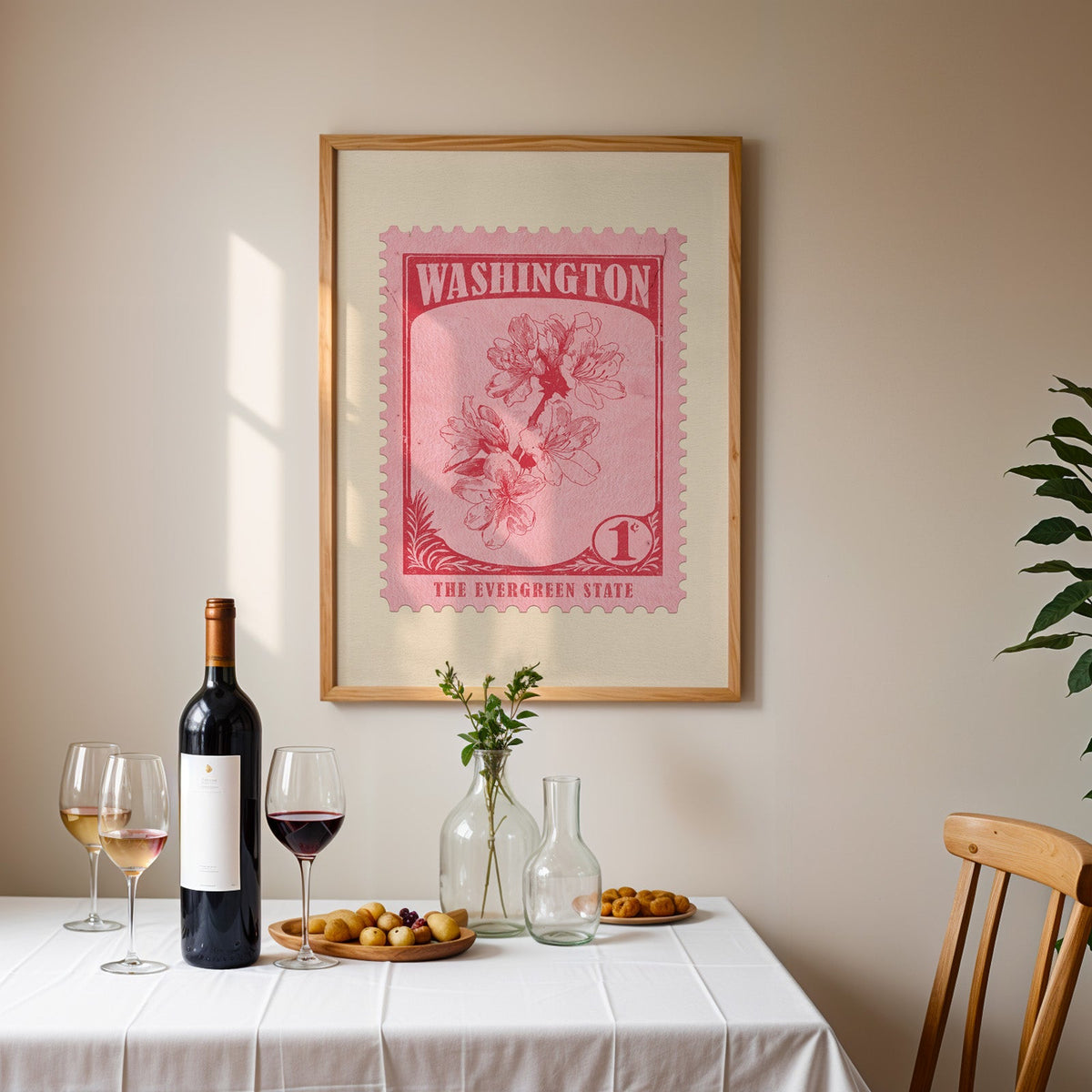 Washington stamp print framed on the wall above a dining table set with wine, glasses and olives