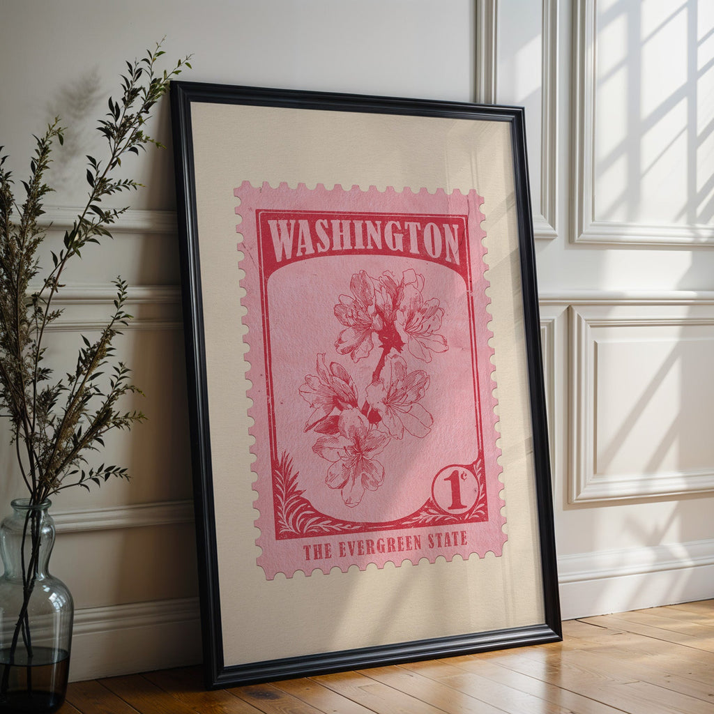 Washington state flower print in a black frame leaning against a white panelled wall beside olive branches