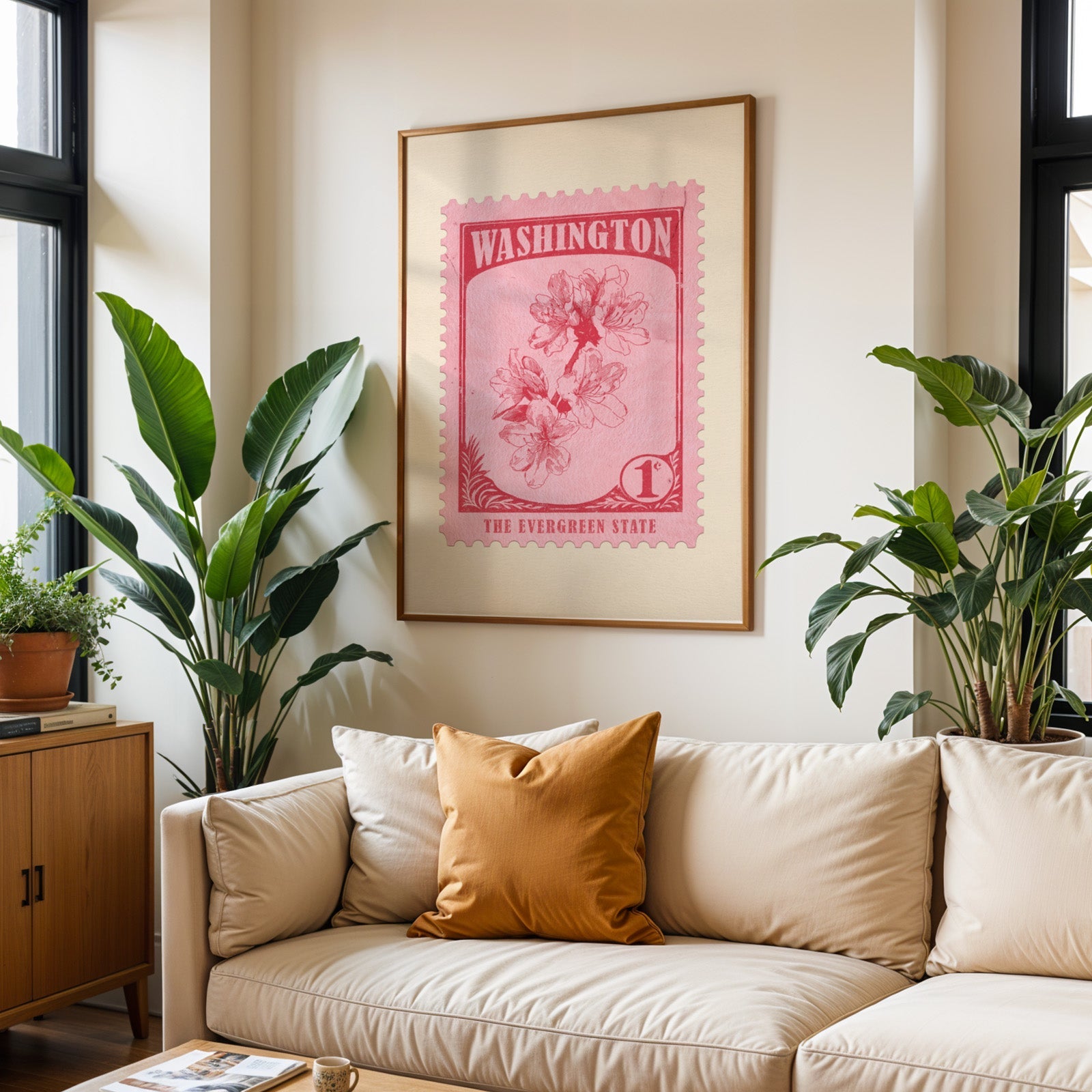 Washington state flower print framed above a cream sofa with an ochre cushion and large plants either side