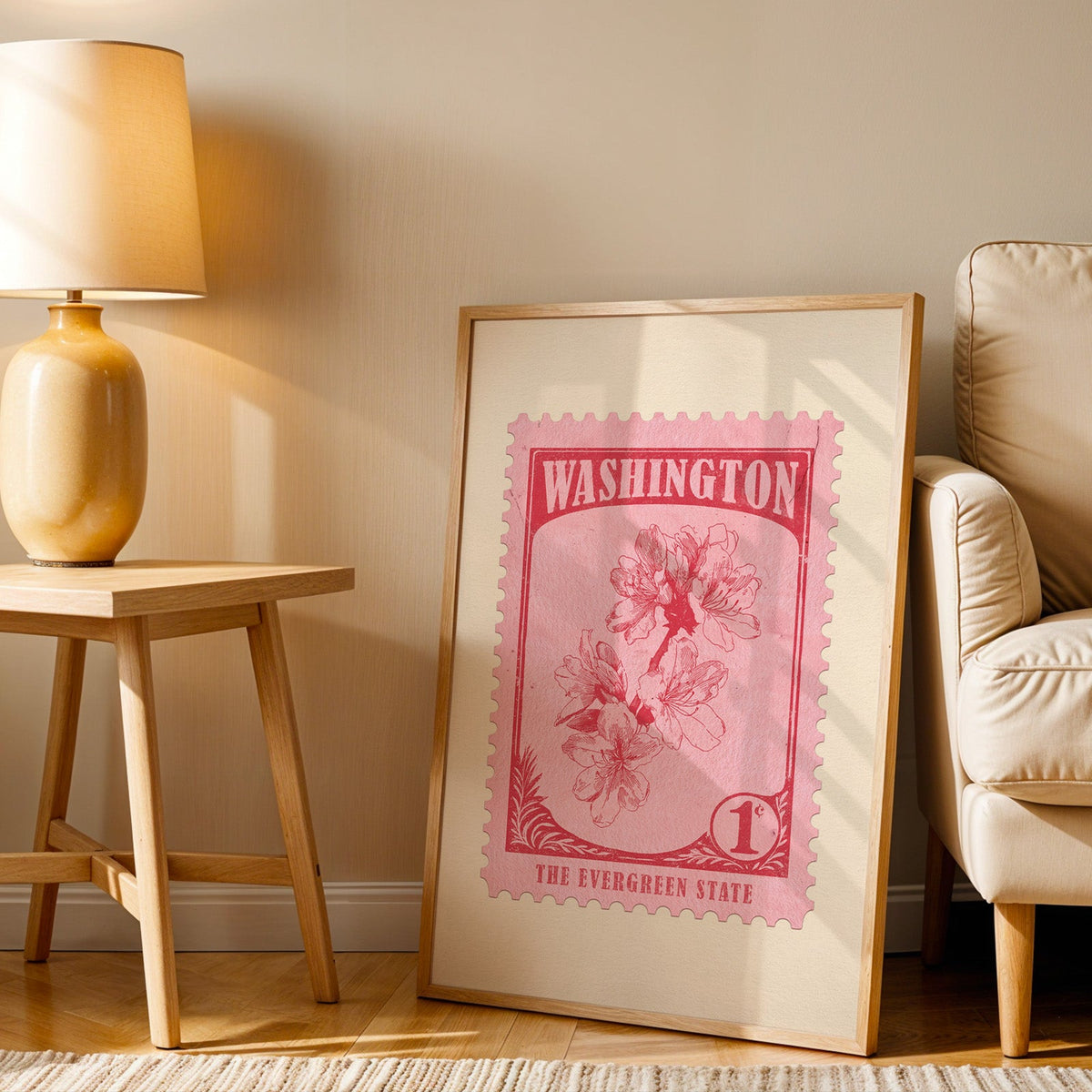 Washington stamp print in a wood frame resting on the floor beside a beige armchair and a yellow lamp