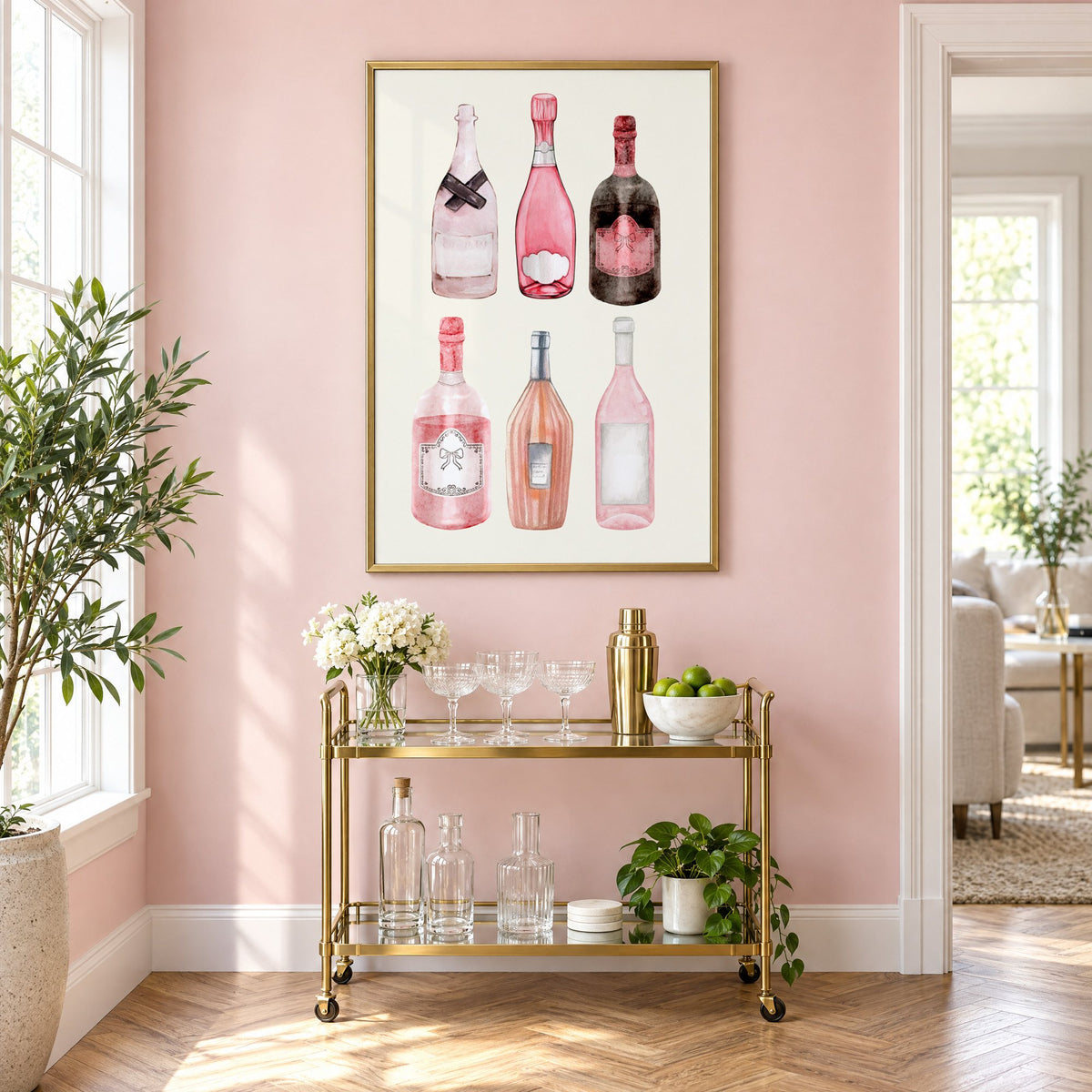 Six pink wine bottles watercolor print in a brass frame above a gold bar cart on a blush pink wall