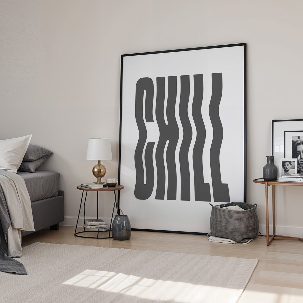 Wavy CHILL lettering on white print in a black frame leaning in a bedroom beside a gold lamp