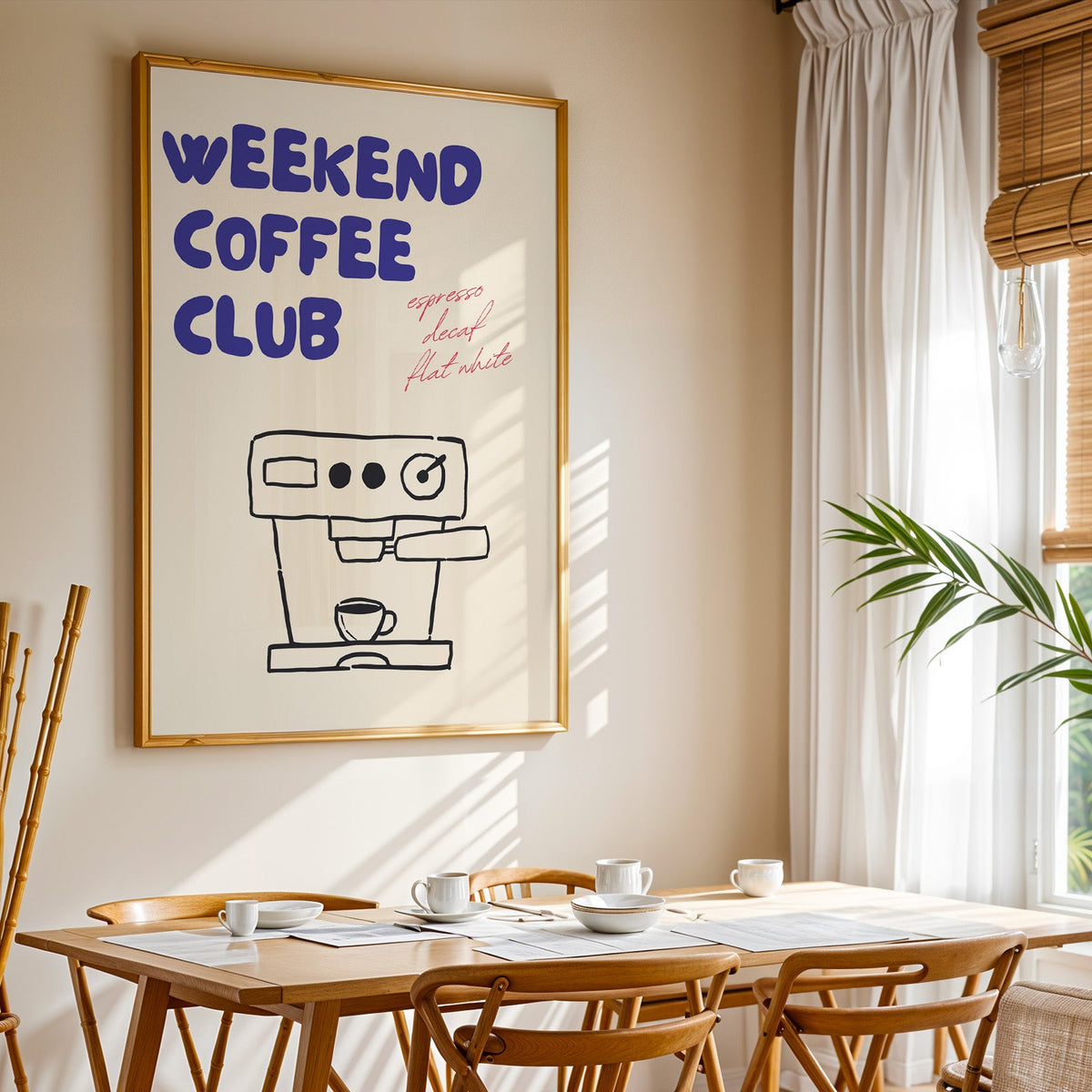 Weekend Coffee Club print shown in a gold frame above a breakfast table by a curtained window