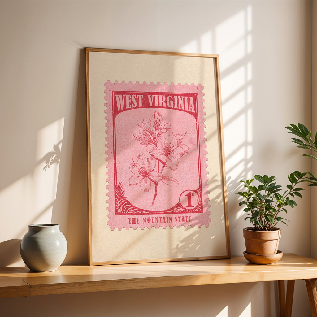 West Virginia Rhododendron stamp print in a light oak frame leaning on a table by a stoneware vase