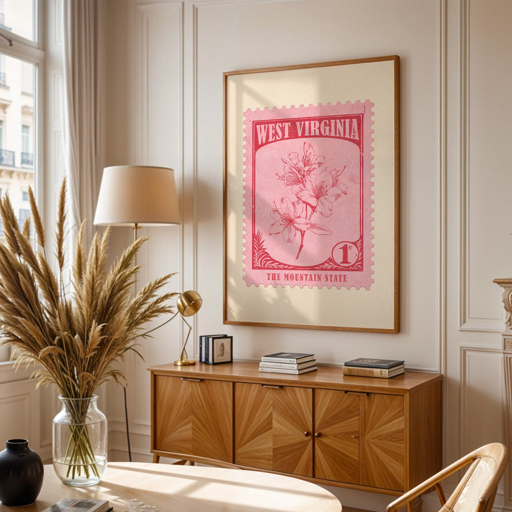 West Virginia stamp print framed above a wooden sideboard, pampas grass in a vase and a floor lamp