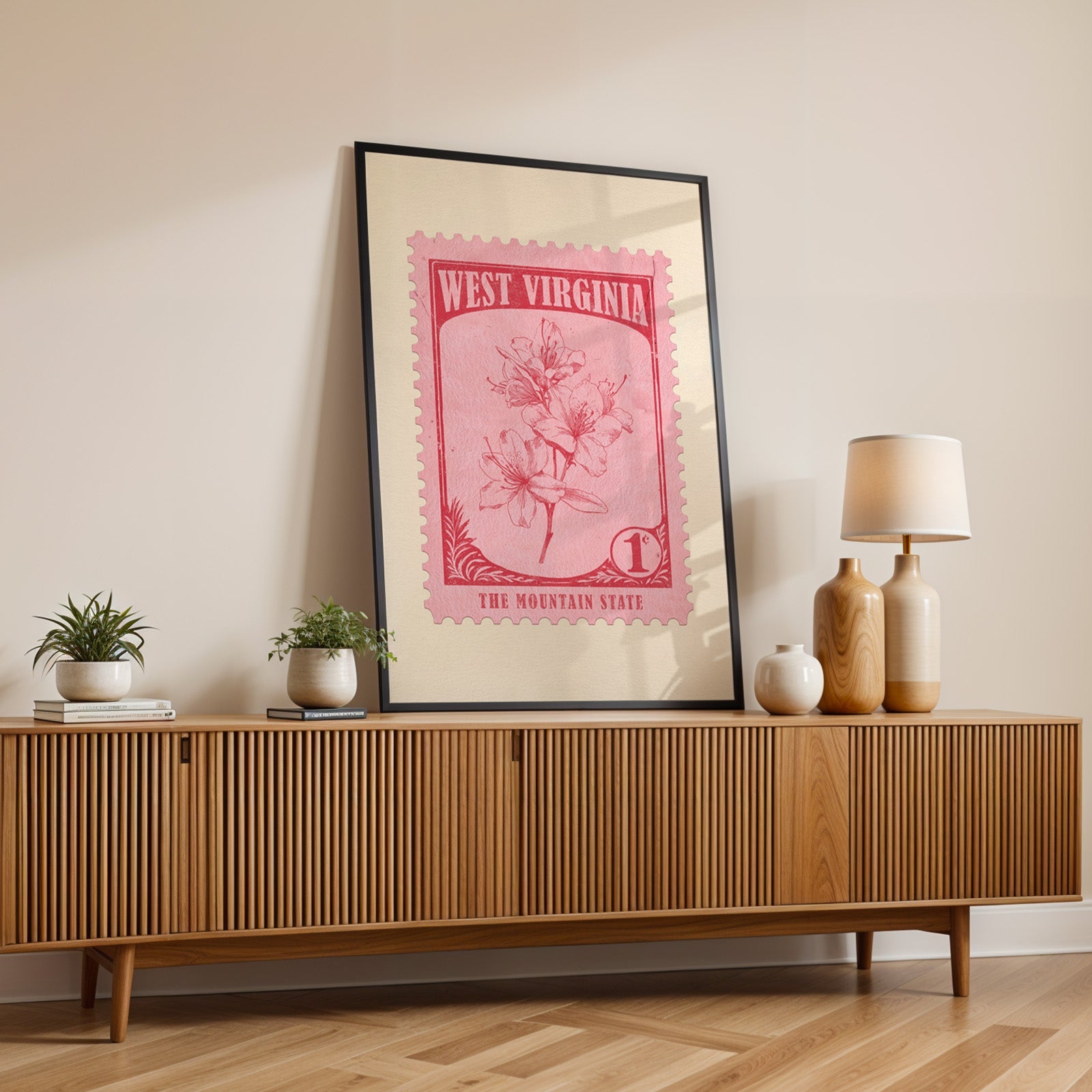 West Virginia state flower print in a black frame leaning on a fluted wood credenza with a lamp
