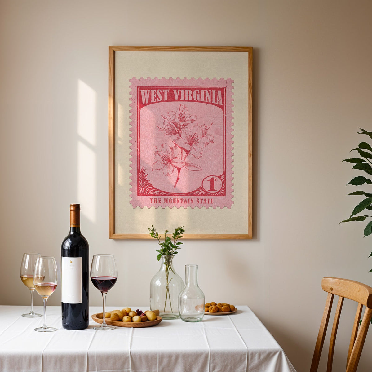 West Virginia stamp print framed on the wall above a dining table set with wine, glasses and olives