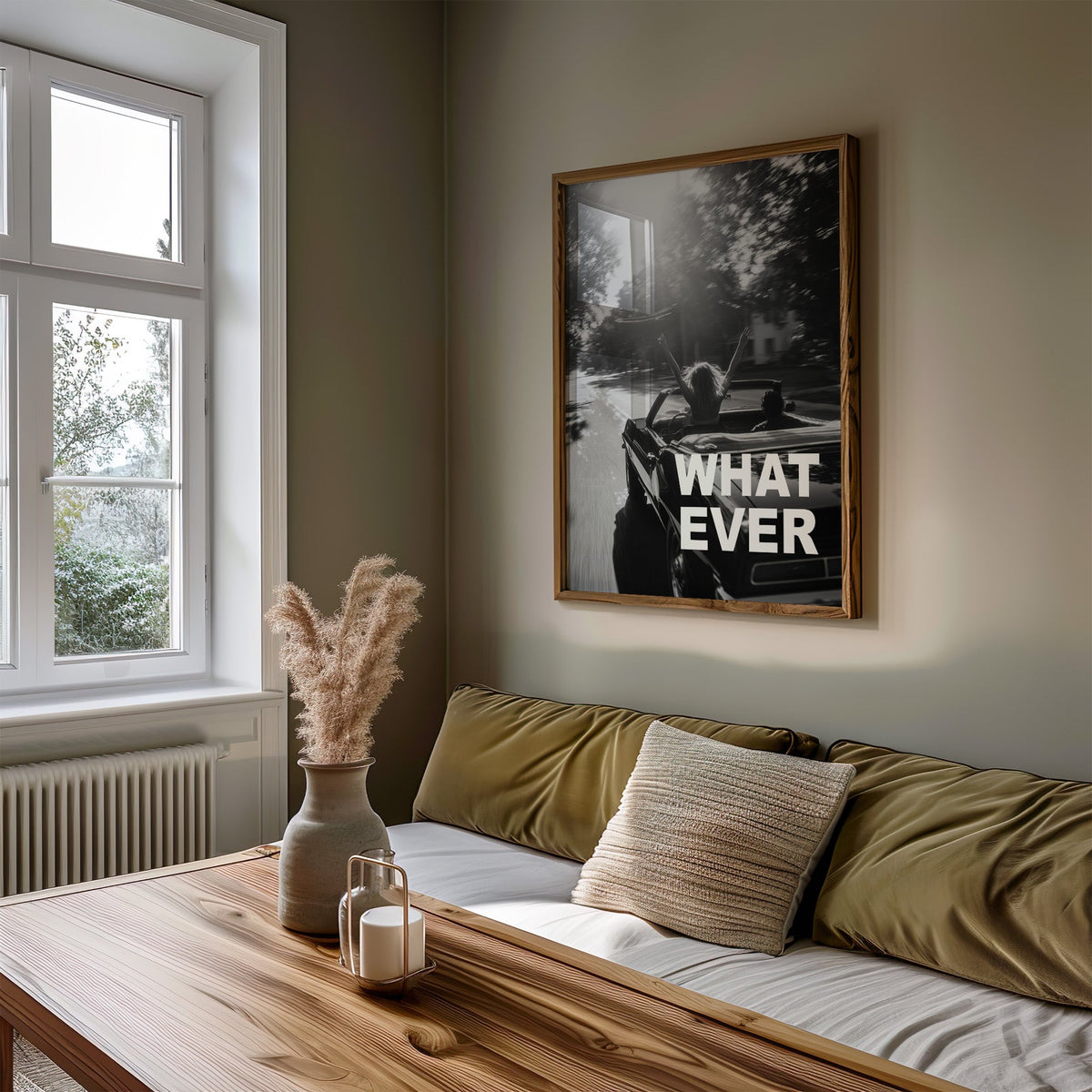Convertible road trip photo with WHAT EVER text print in a walnut frame above an olive daybed by a window