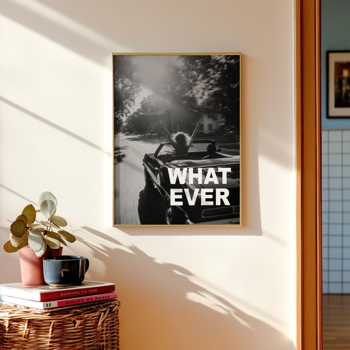 Convertible road trip photo with WHAT EVER text print shown in a gold frame above a wicker basket and stacked books