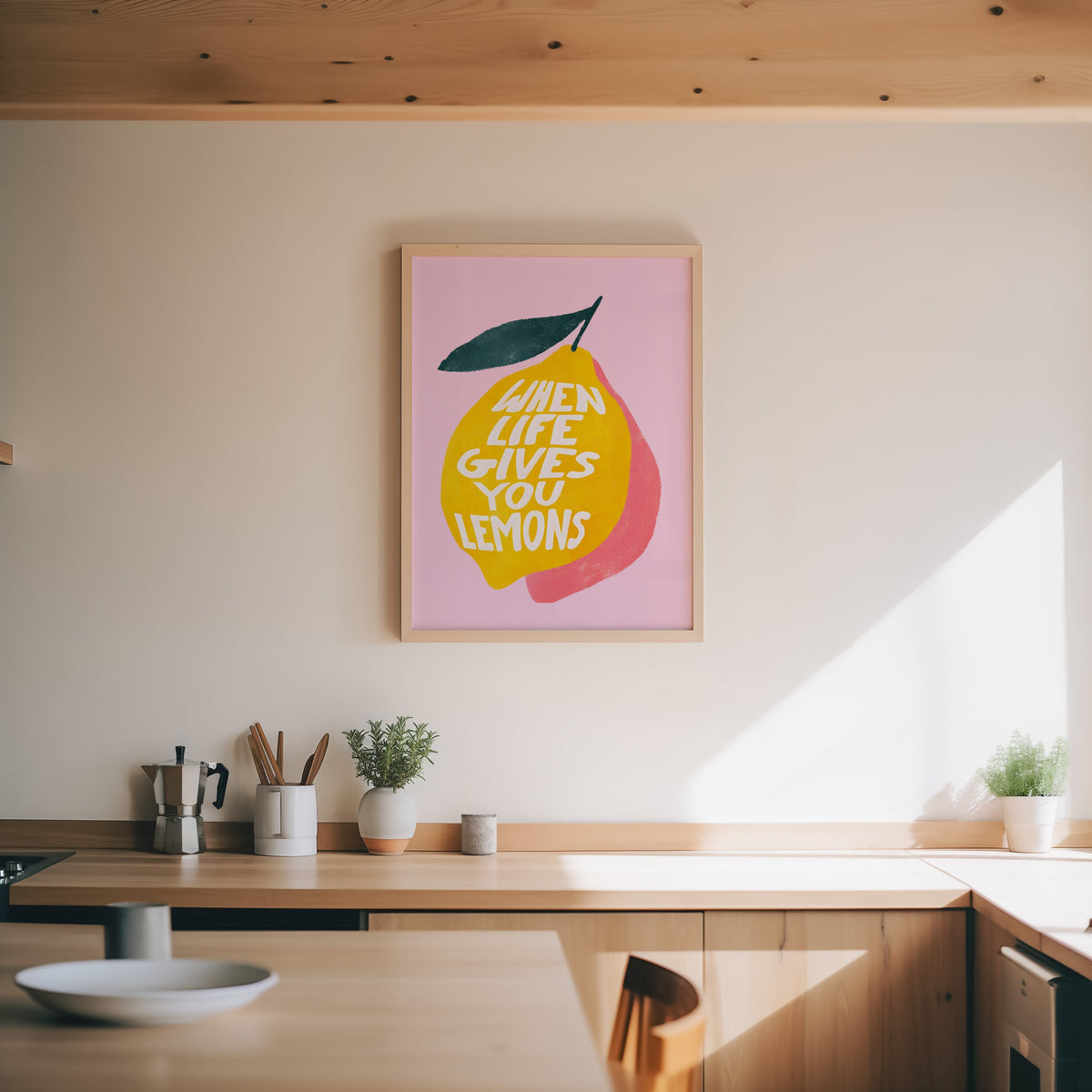 Lemon quote print in an oak frame above a wood counter with a moka pot and herbs