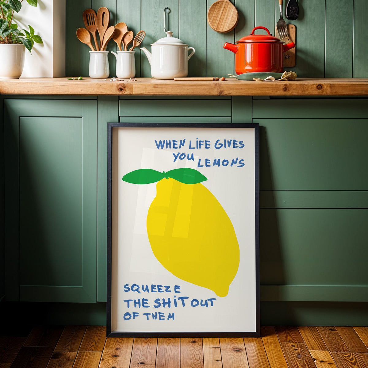 When life gives you lemons print in a black frame against sage green cabinets