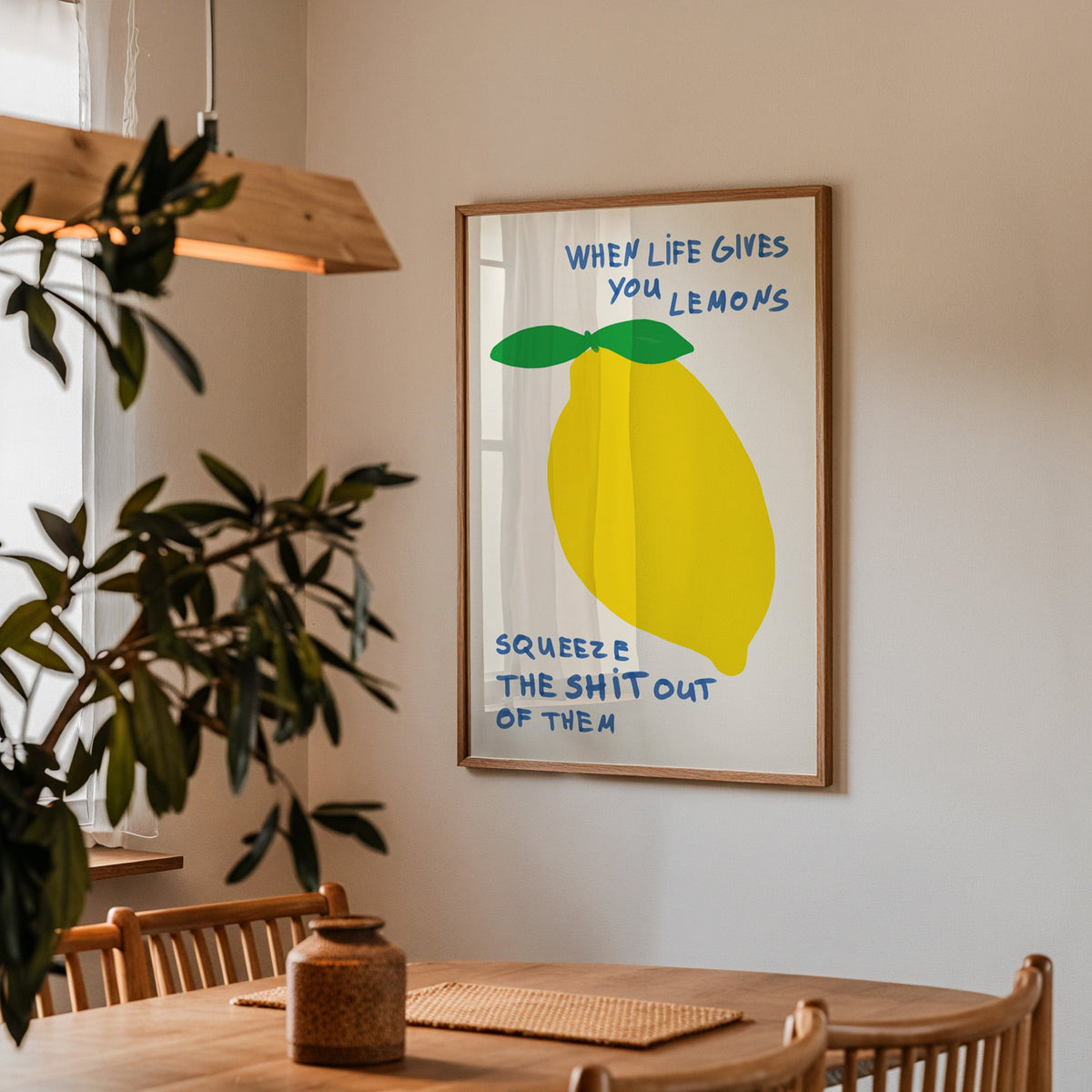 When life gives you lemons print in a walnut frame above a table by an olive tree