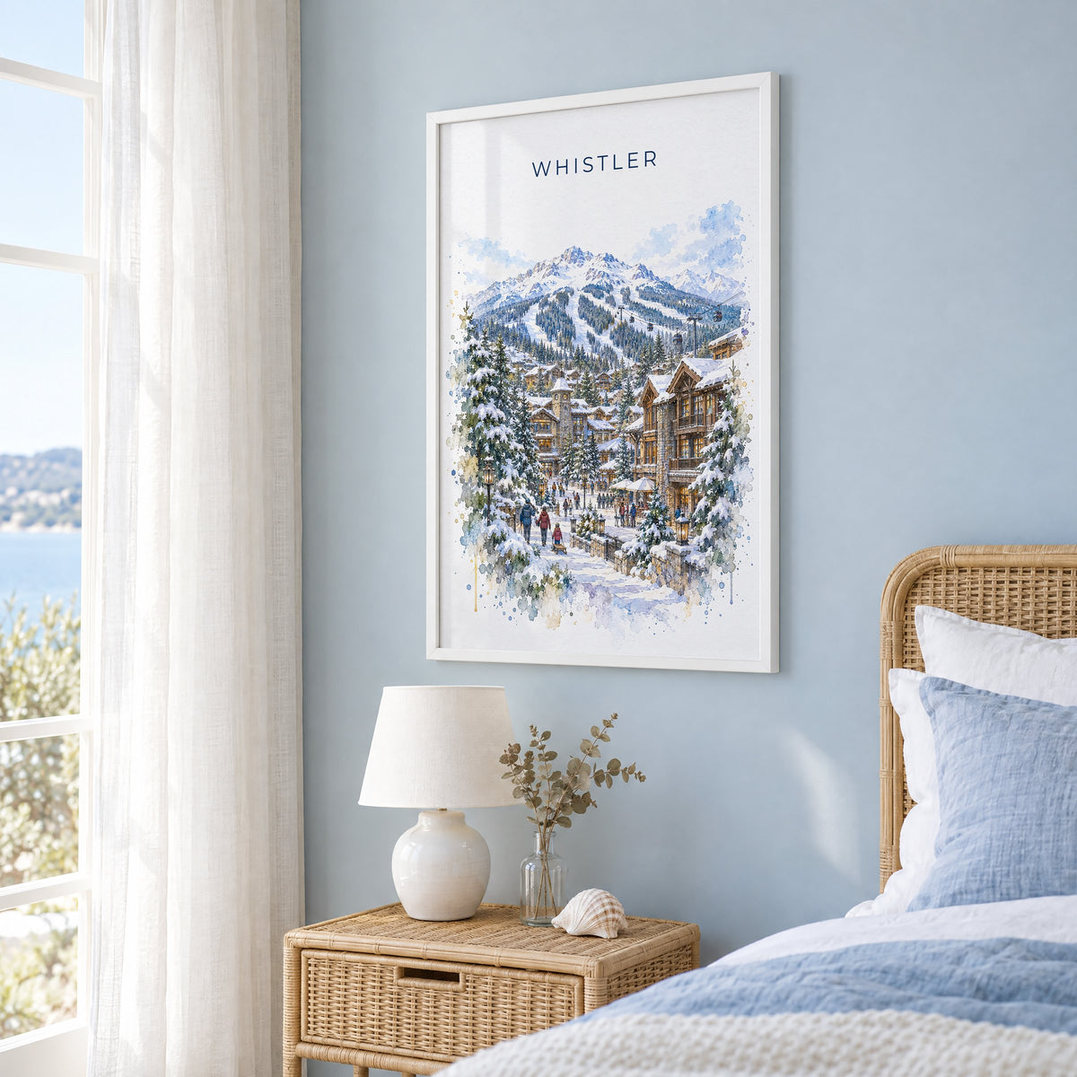 Whistler watercolor print in a white frame on a pale blue wall beside a rattan bed in a coastal bedroom