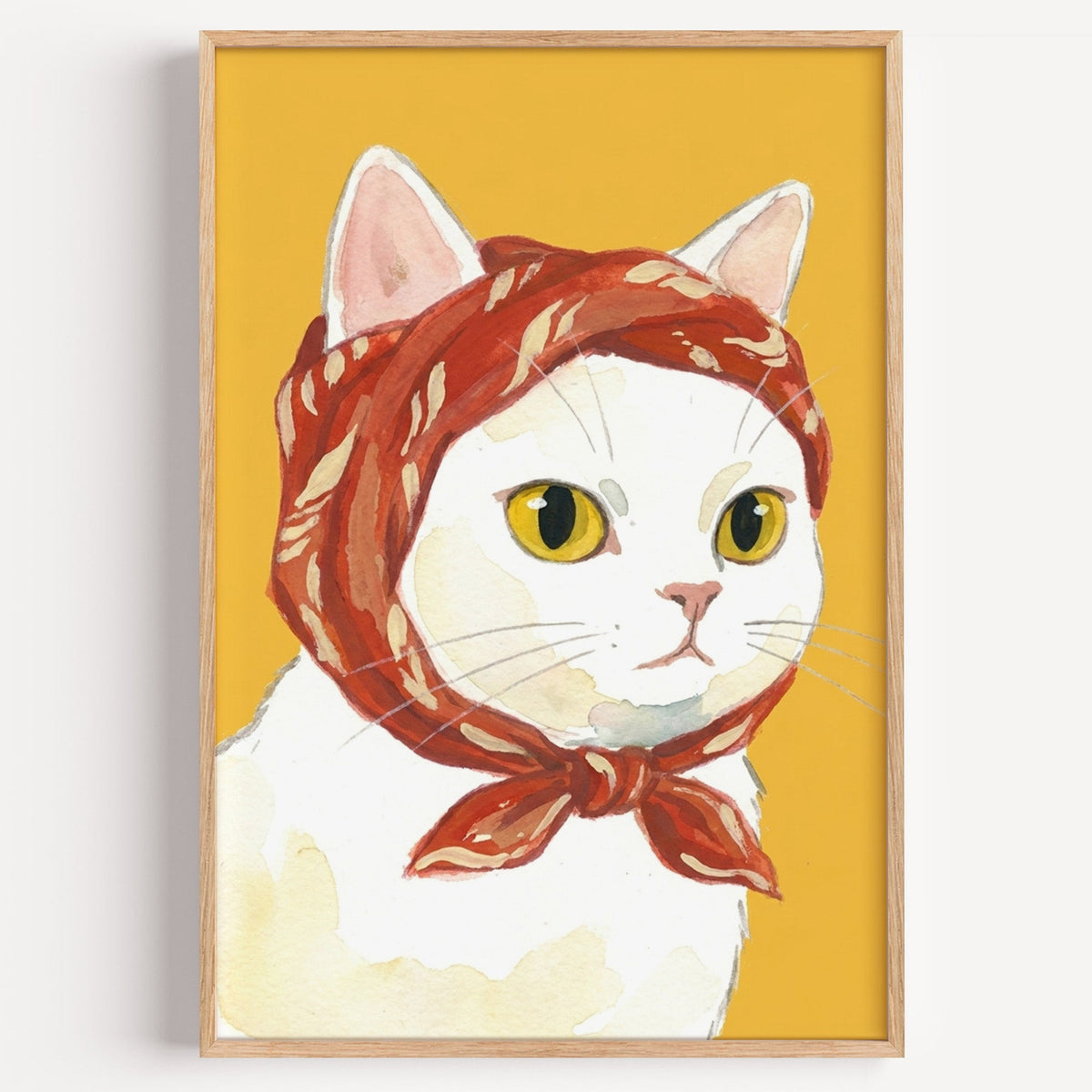 White cat in red headscarf print in a light oak frame on a plain white wall