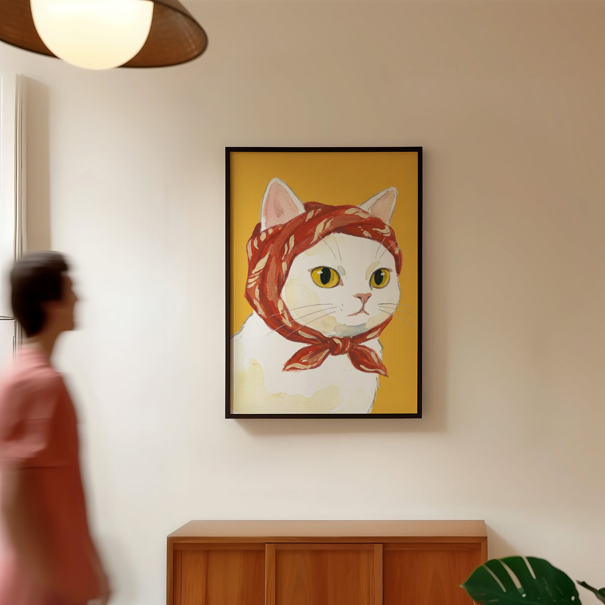 Yellow and red cat print in a black frame in a hallway under a rattan pendant