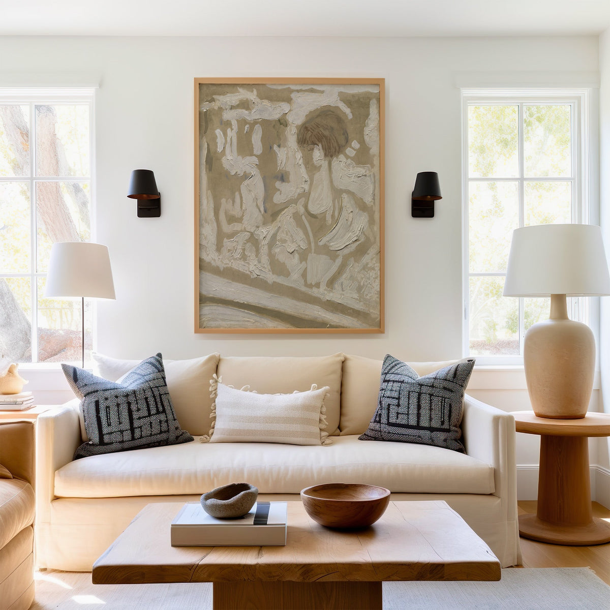 White impasto with bob hair figure sketch print in a light oak frame above a cream sofa between two black wall sconces
