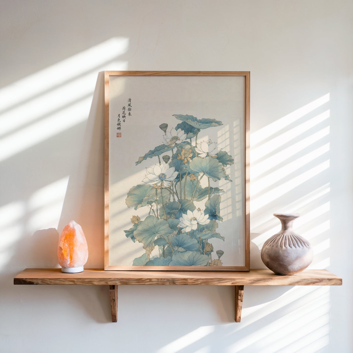 white lotus pond with verse print in an oak frame on a live-edge wall shelf with a salt lamp and clay vase
