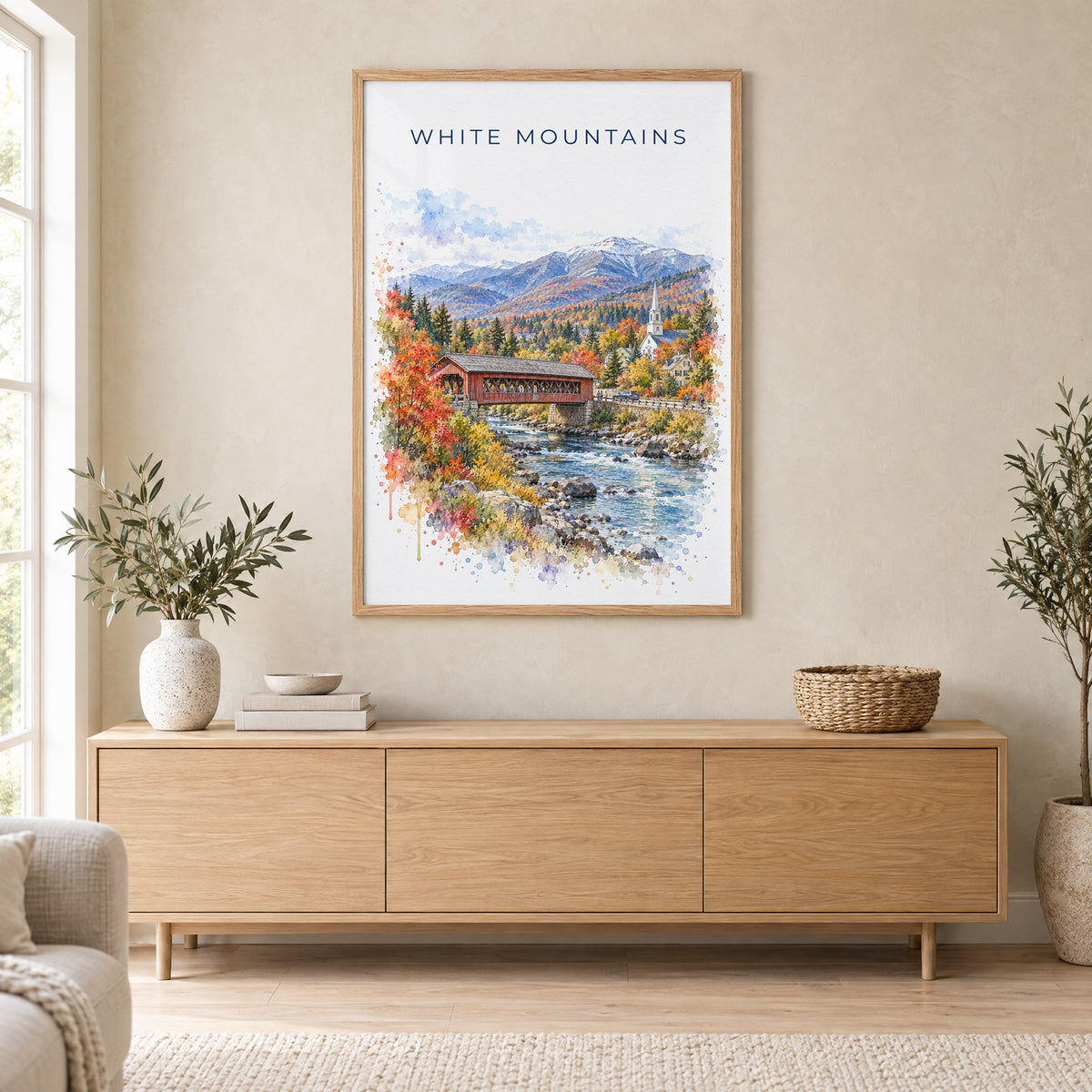 White Mountains, New Hampshire watercolor print in an oak frame above a light wood sideboard in a Scandinavian living room