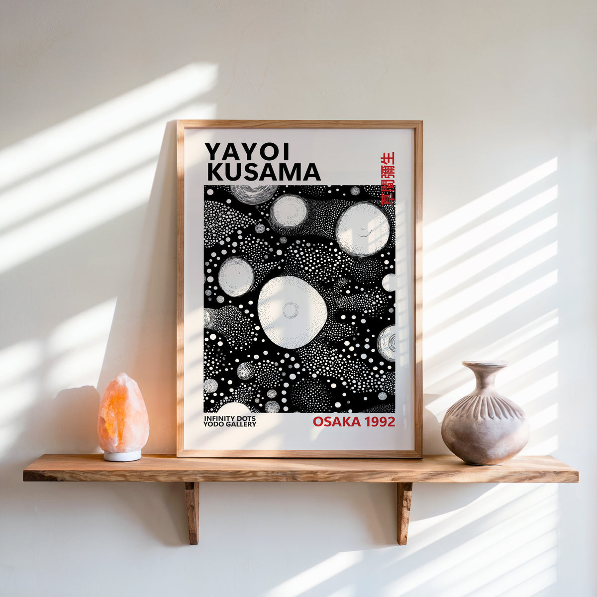 Yayoi Kusama inspired white orbs on black print above a shelf with a salt lamp