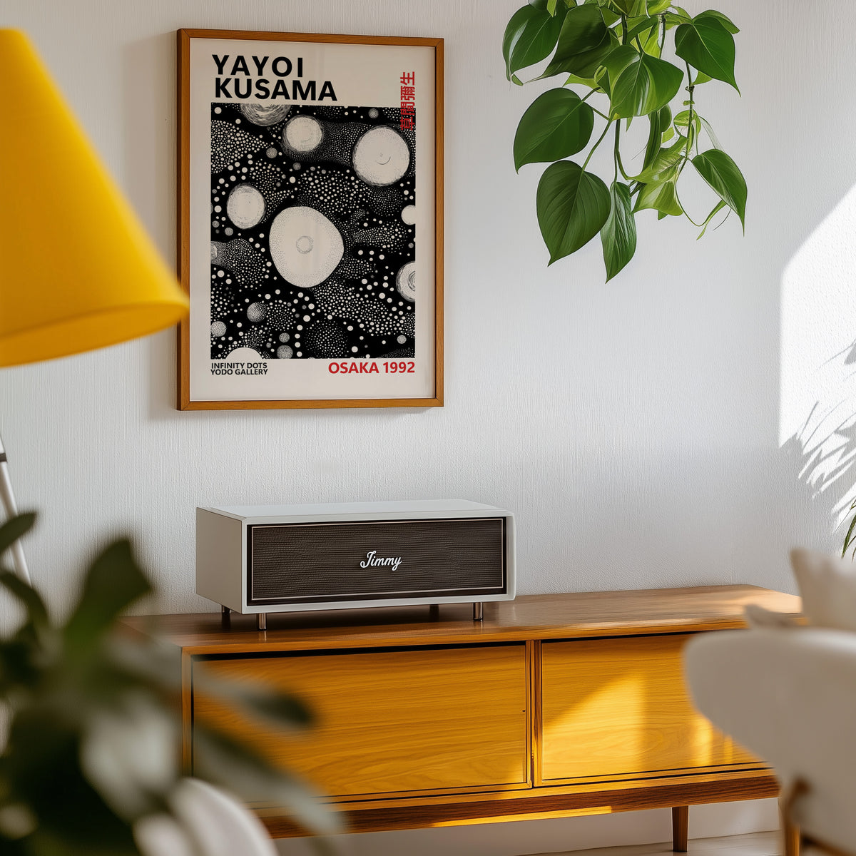 Yayoi Kusama inspired white orbs on black print above a sideboard with a plant