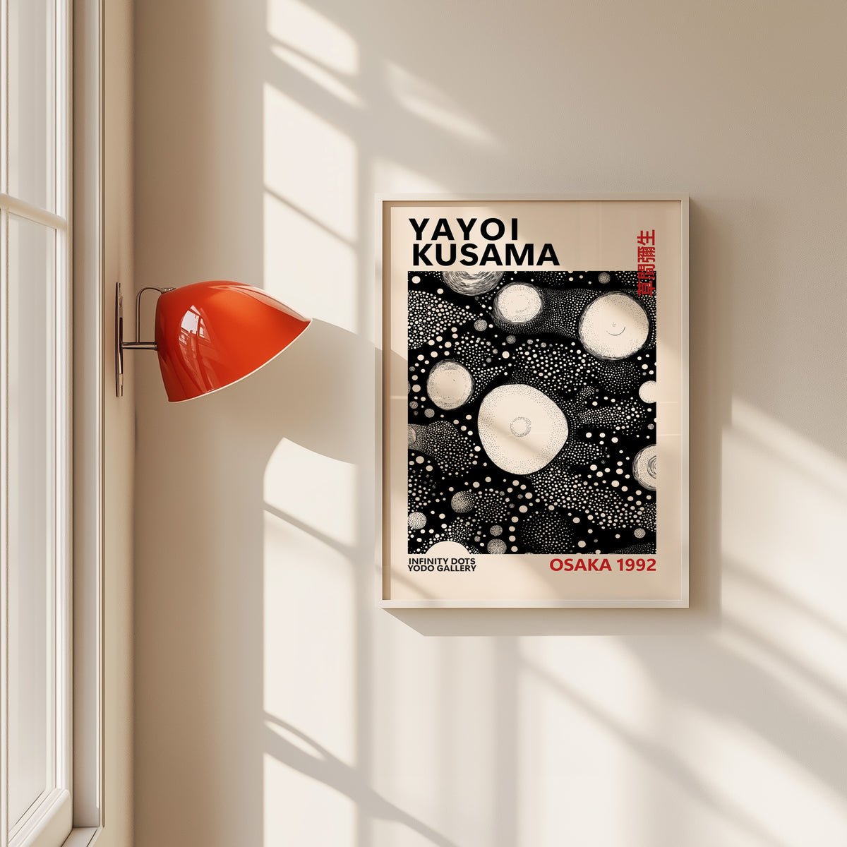 Yayoi Kusama inspired white orbs on black print in a white frame by a red wall lamp