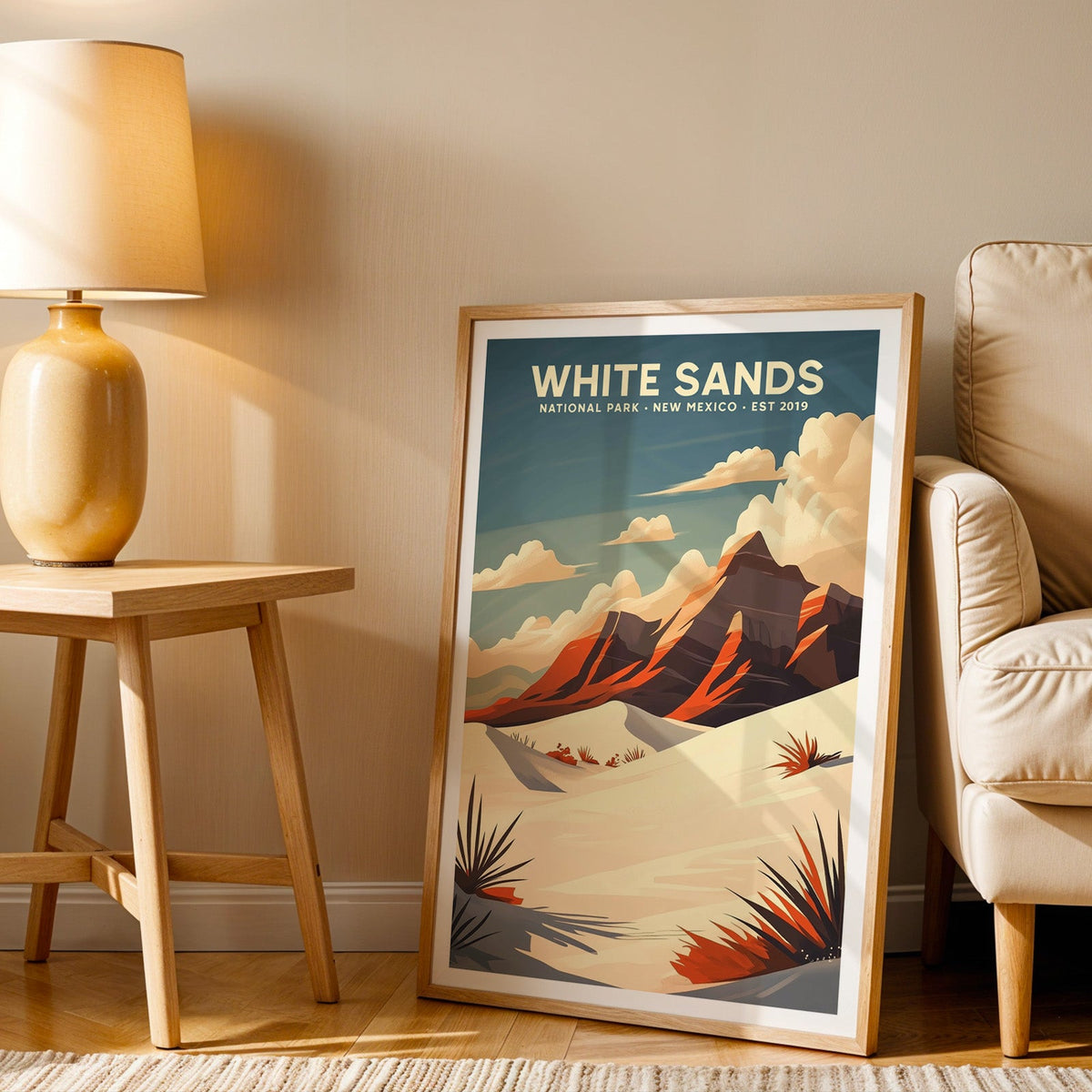White Sands print in an oak frame beside a cream armchair and an amber lamp in warm afternoon light