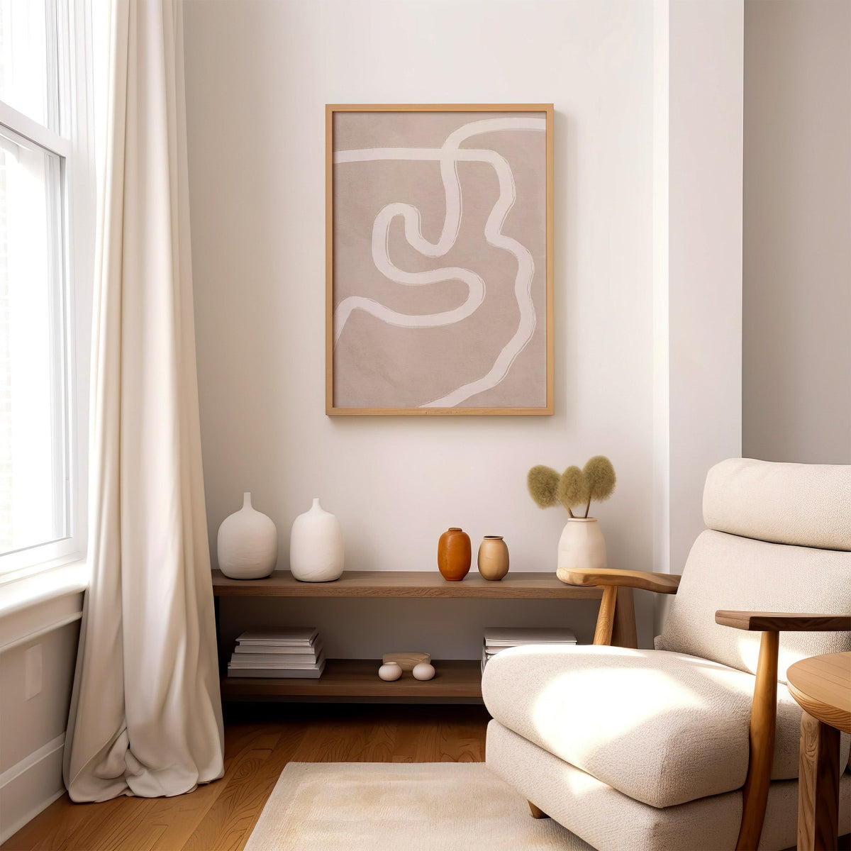 White squiggle brushstroke on taupe boho print in an oak frame above a wood console shelf by a cream boucle armchair