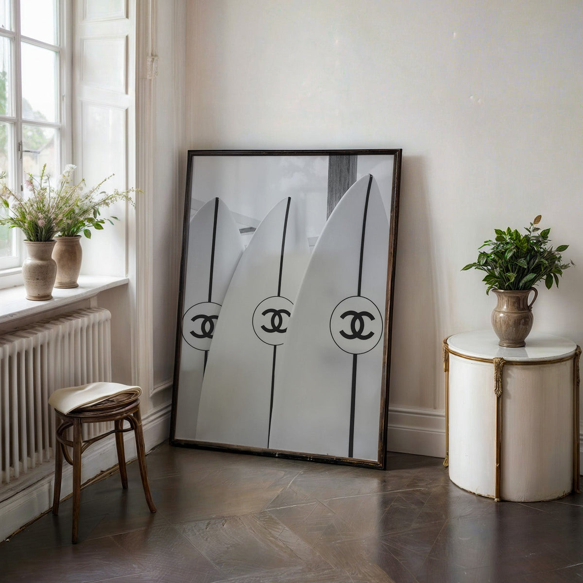 Three white surfboards with black stripes print in a black frame on a dark stone floor beside a white side table