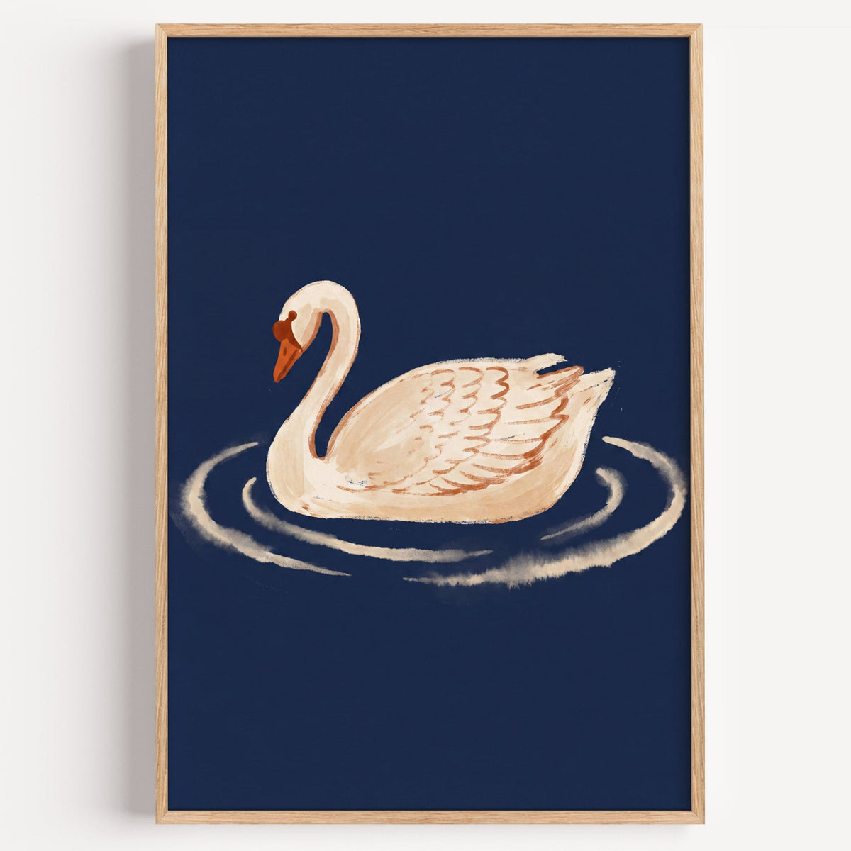 White swan on navy print in a light oak frame on a plain white wall