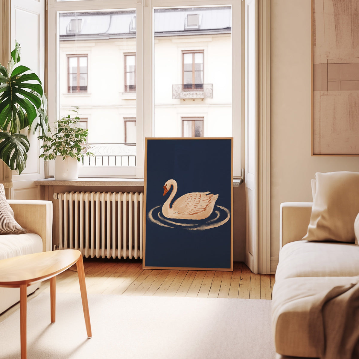 Navy swan wall art print in an oak frame leaning below tall French windows