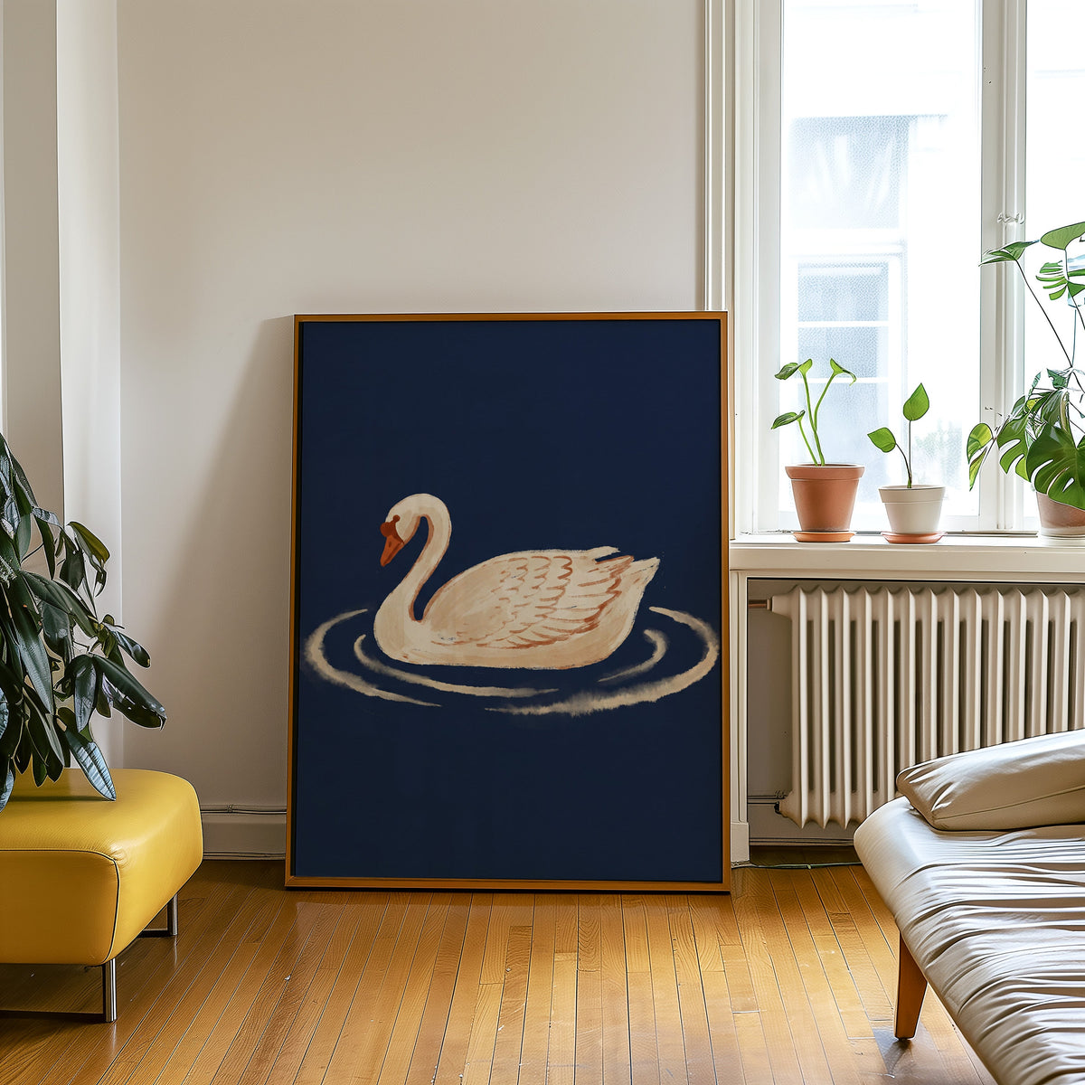 Cream swan painting print in an oak frame leaning beside a yellow leather bench