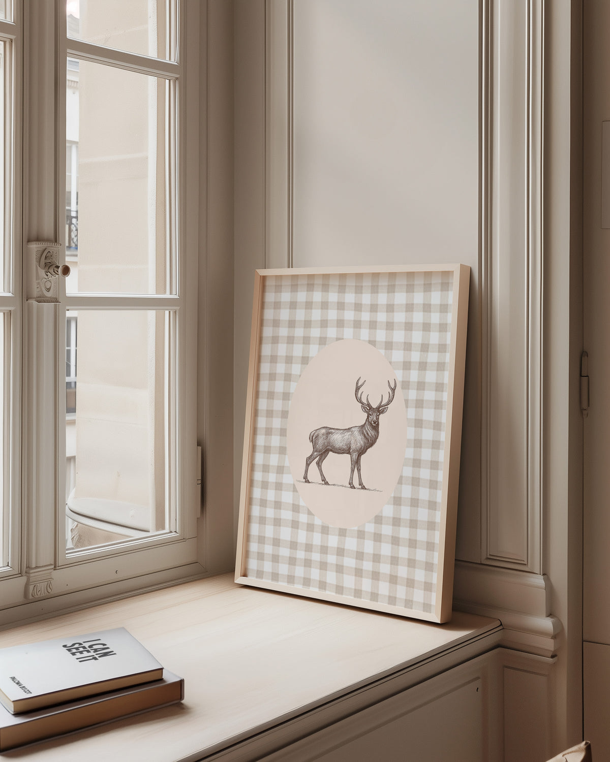 Whitetail deer cameo print in a pale wood frame on a sunlit window ledge