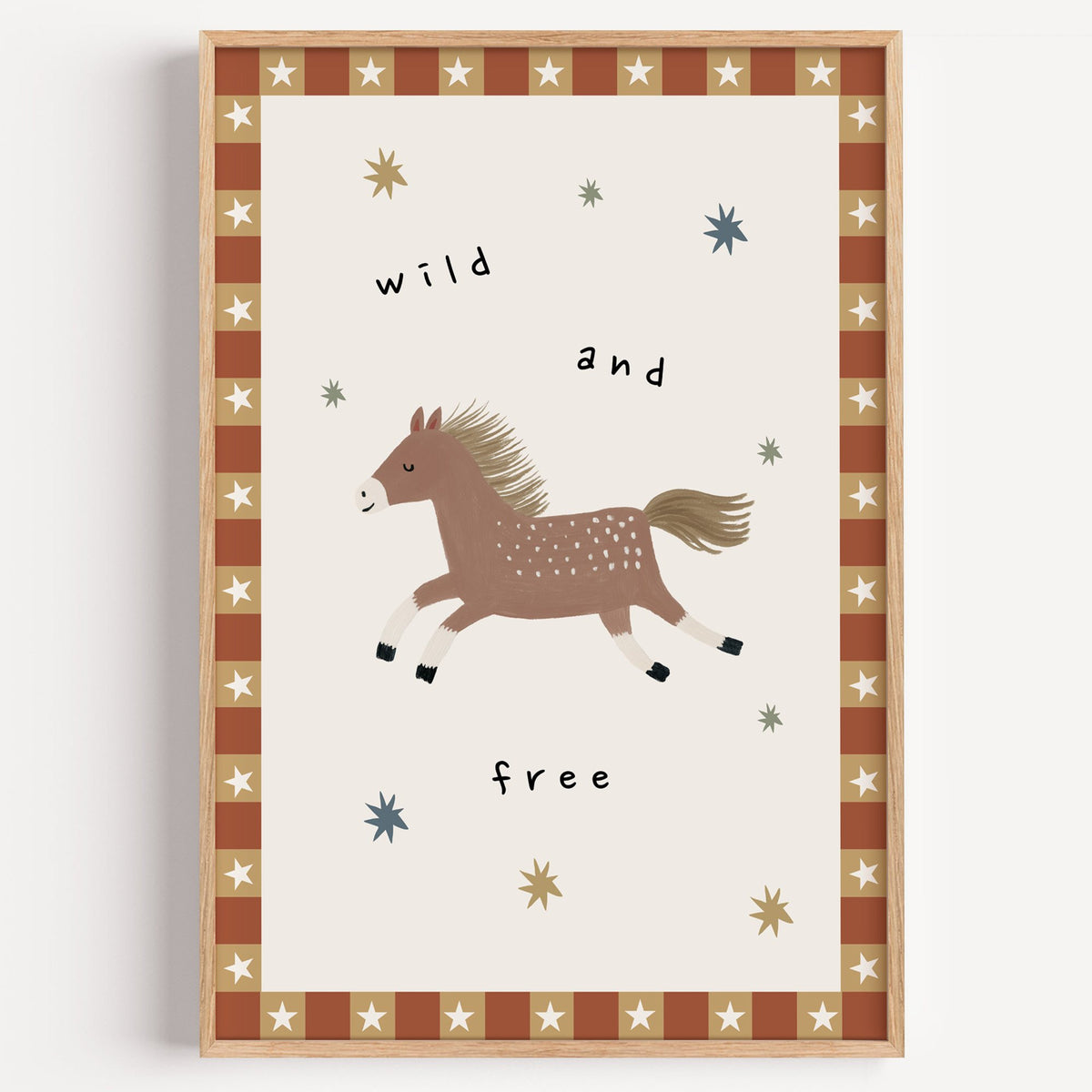Wild and free pony nursery print in a light oak frame on a plain white wall