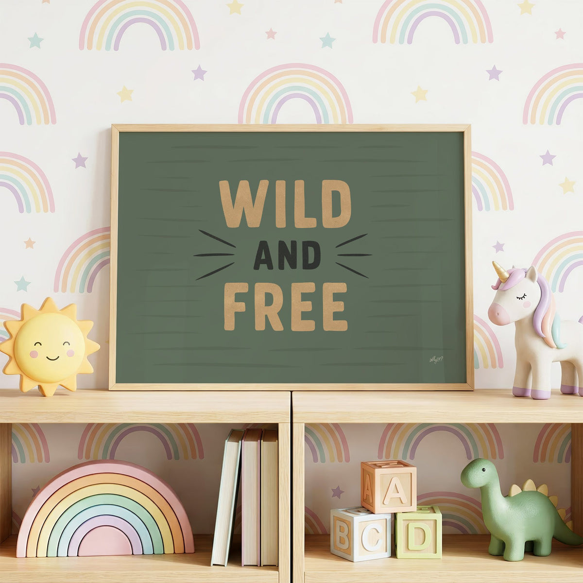 Wild and free sage green quote nursery print in an oak frame on a toy shelf against rainbow wallpaper