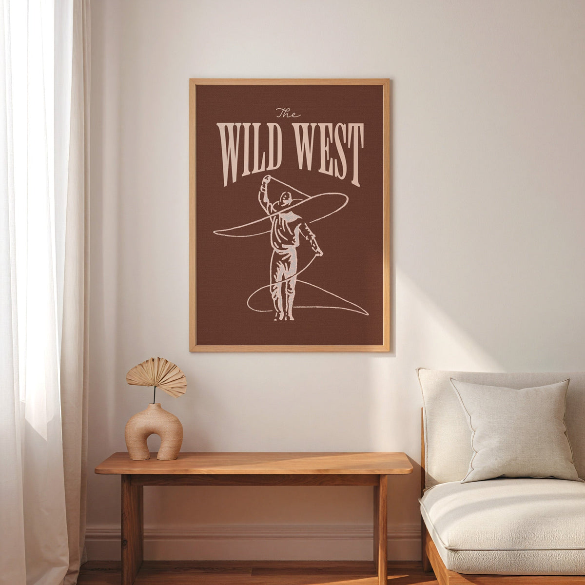 The Wild West lasso brown print in an oak frame above a console with an arch vase