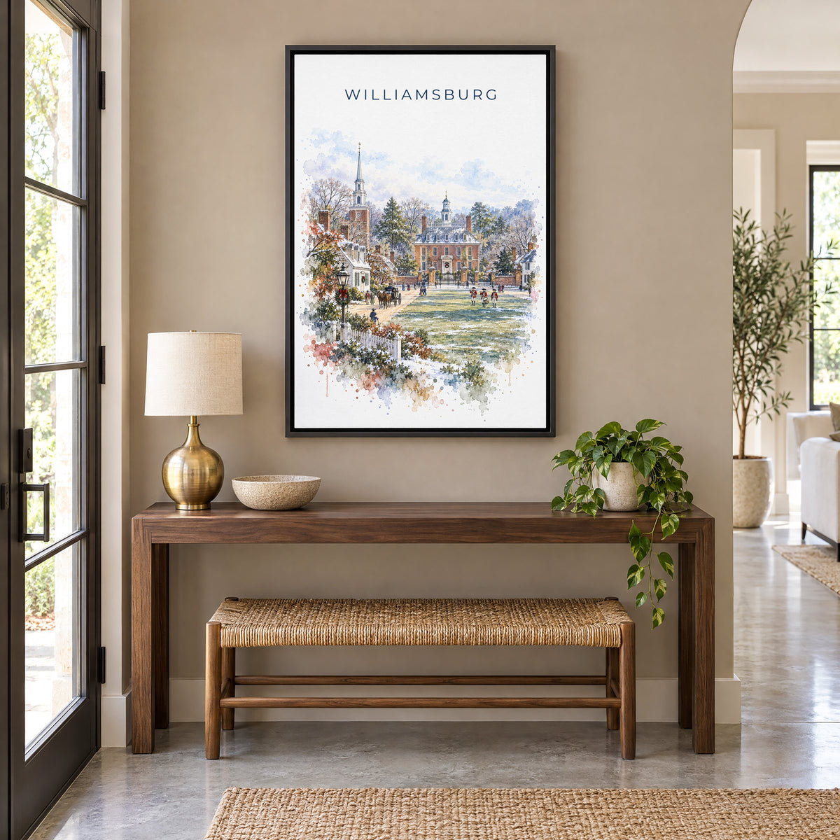 Williamsburg, Virginia watercolor print as a black floater canvas above a walnut console and woven bench in an entryway