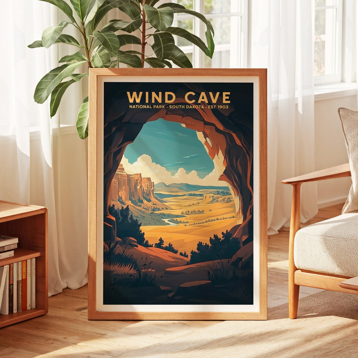 Wind Cave National Park print in an oak frame by a sunlit window with sheer curtains and a fig plant