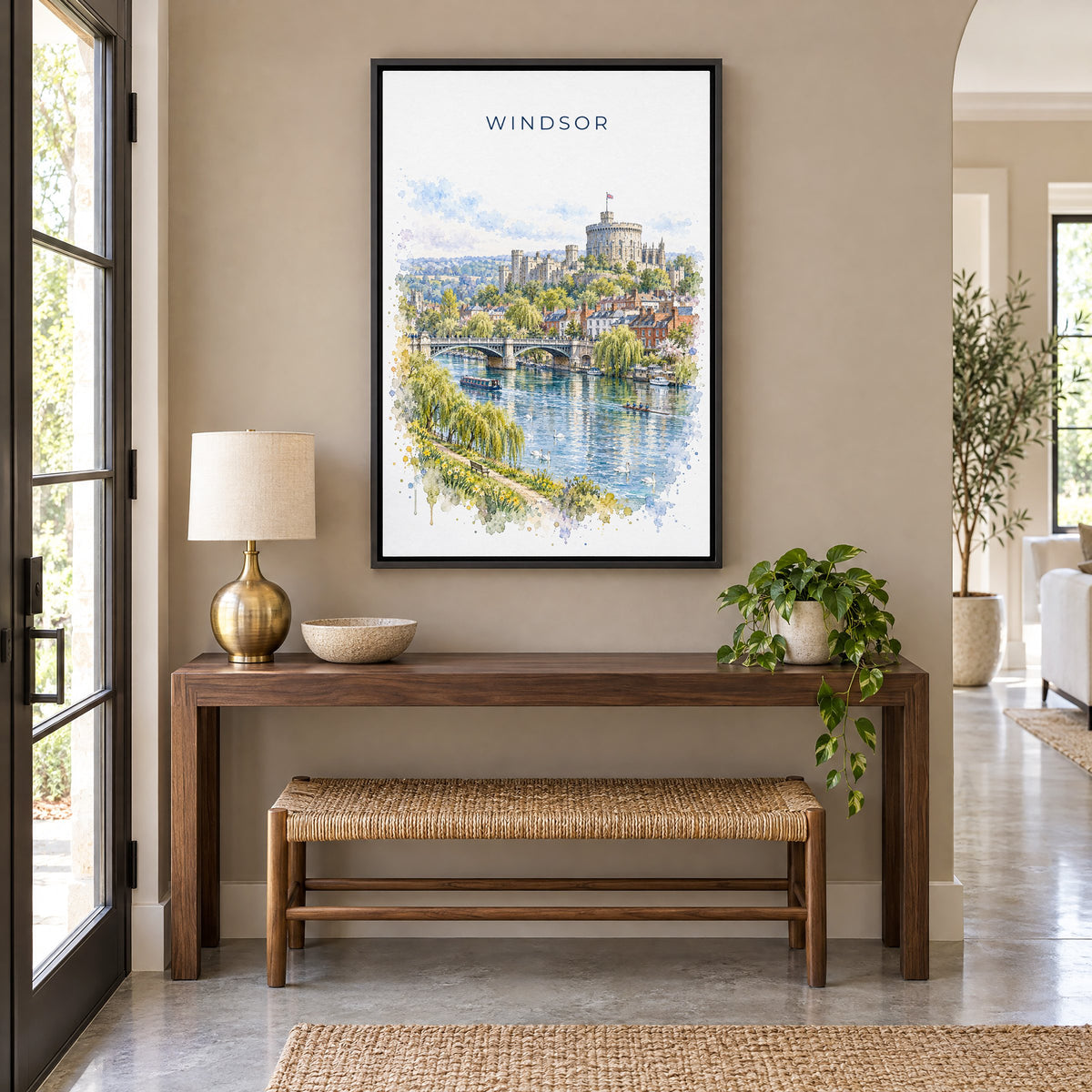 Windsor, England watercolor print as a black floater canvas above a walnut console and woven bench in an entryway