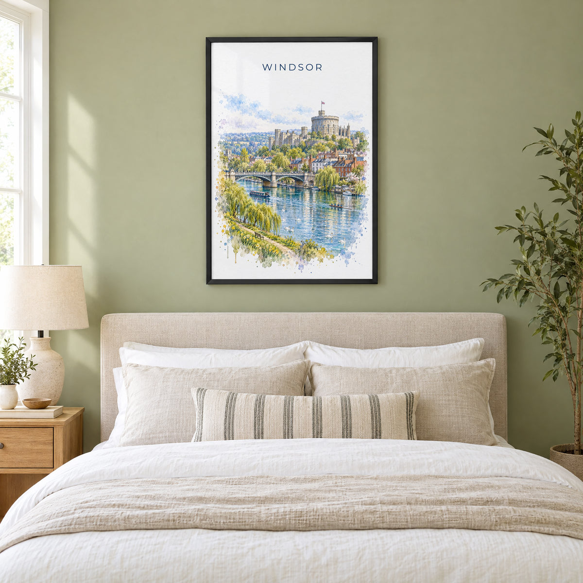 Windsor, England watercolor print in a black frame above an upholstered headboard in a sage green bedroom
