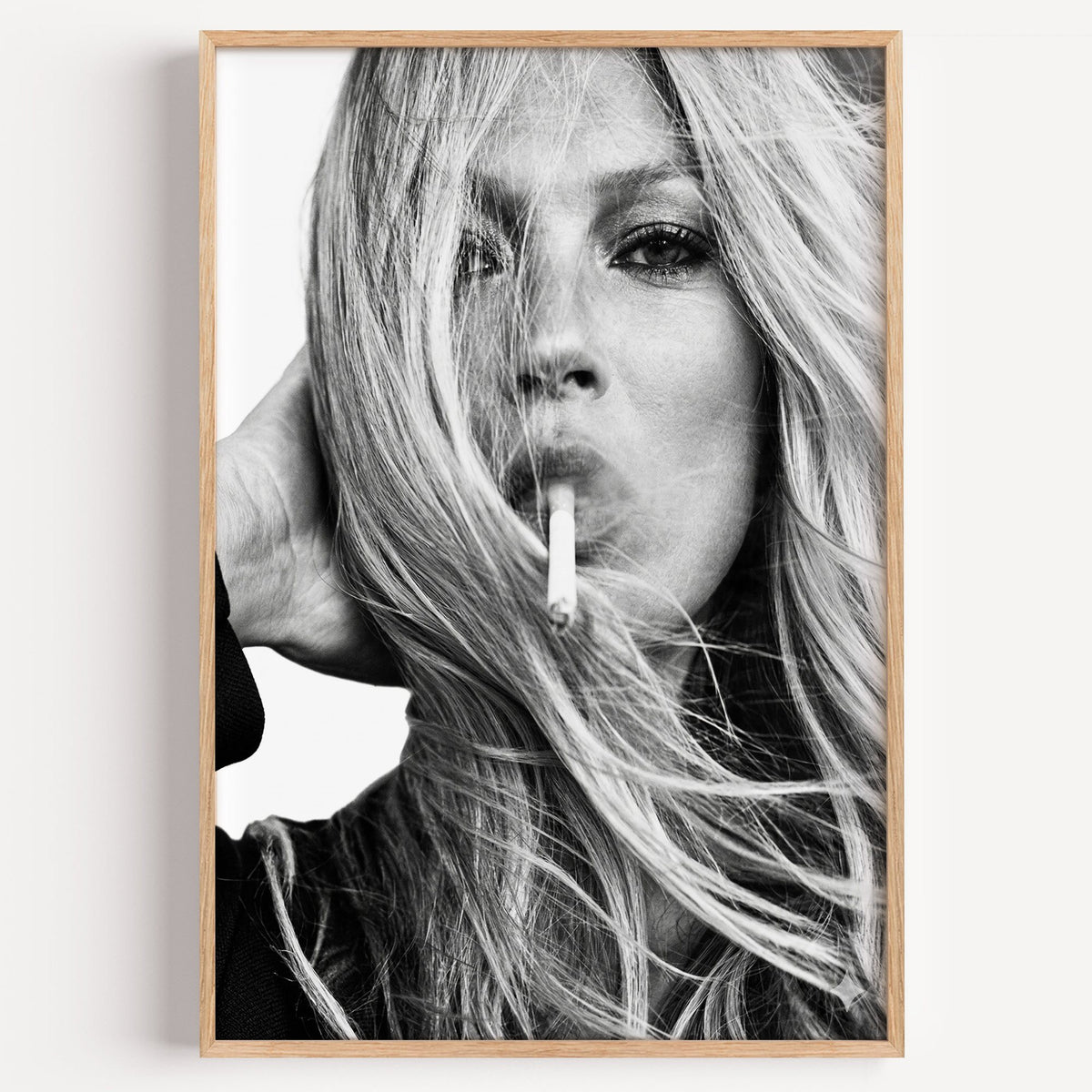 Woman with windswept hair across her face print in a light oak frame on a plain white wall